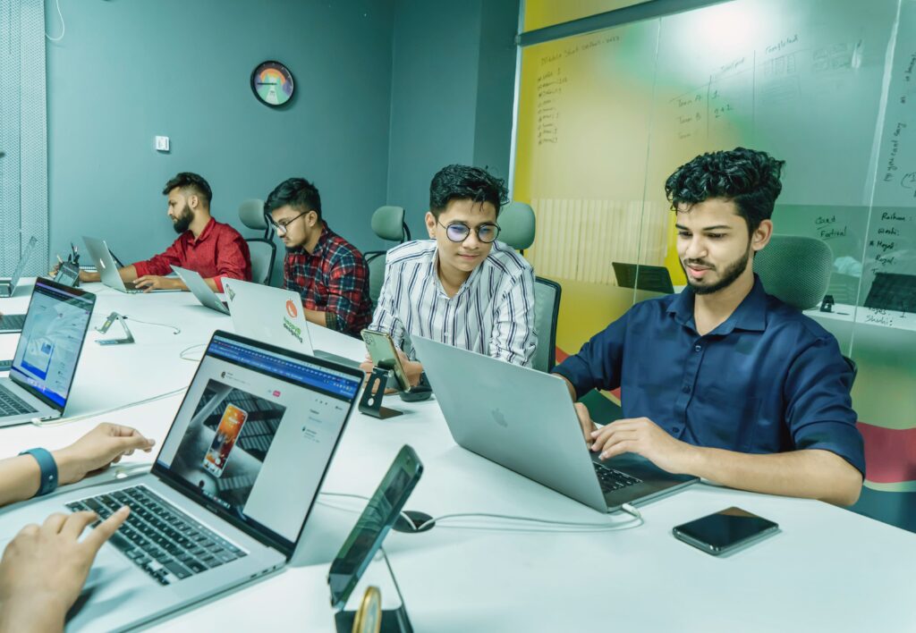 Why Choose a Coworking Space in Federal B Area, Karachi? A Complete Guide for Professionals Group of young professionals working together in a modern office setting, using laptops and technology.